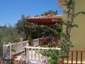Covered dining area by kitchen overlooking olive trees